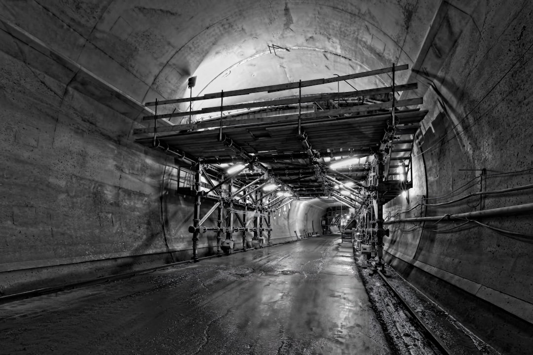 Baustelle eines unterirdischen Bahnhofs mit Betonstützen und Kränen