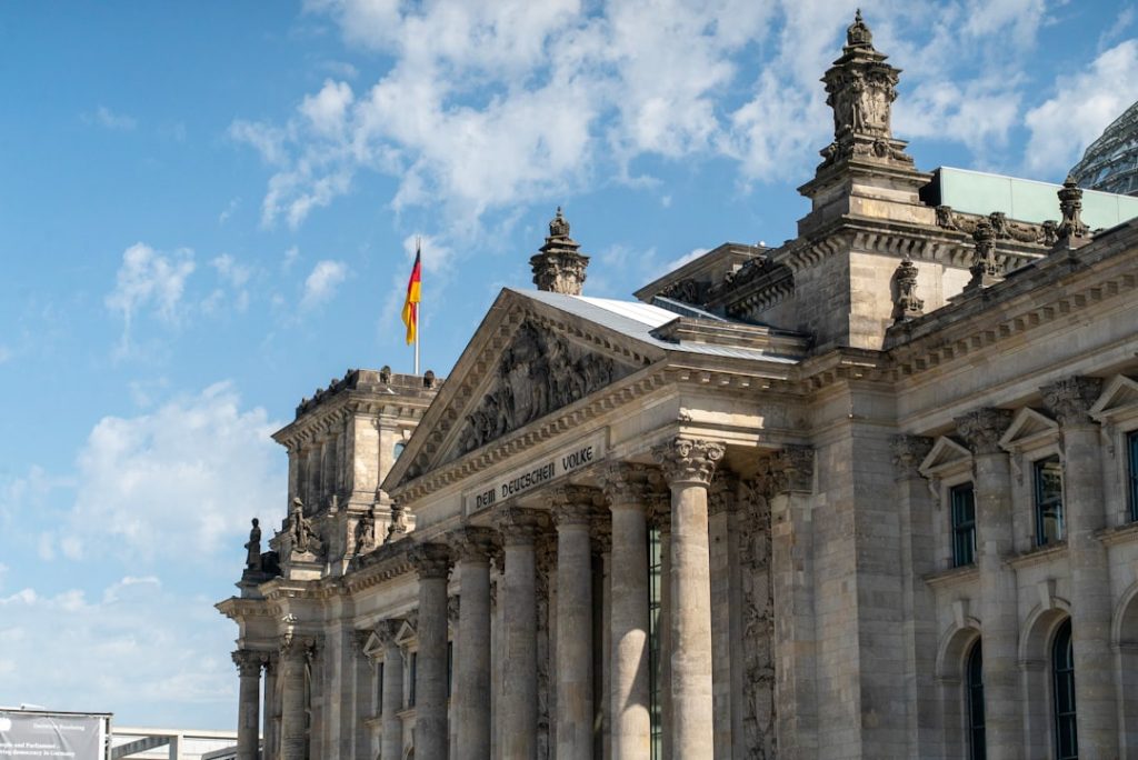 Euro-Geldscheine vor einem Regierungsgebäude als Symbol für die deutschen Staatsschulden