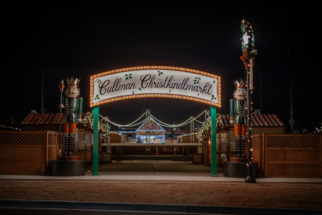Zufahrt zu einem Weihnachtsmarkt mit Betonsperren und Polizeipräsenz am Abend