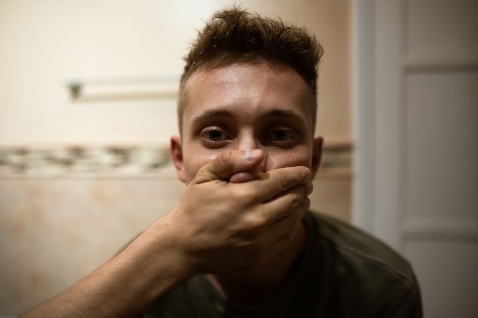 Person hält sich die Hand vor den Mund und schweigt
