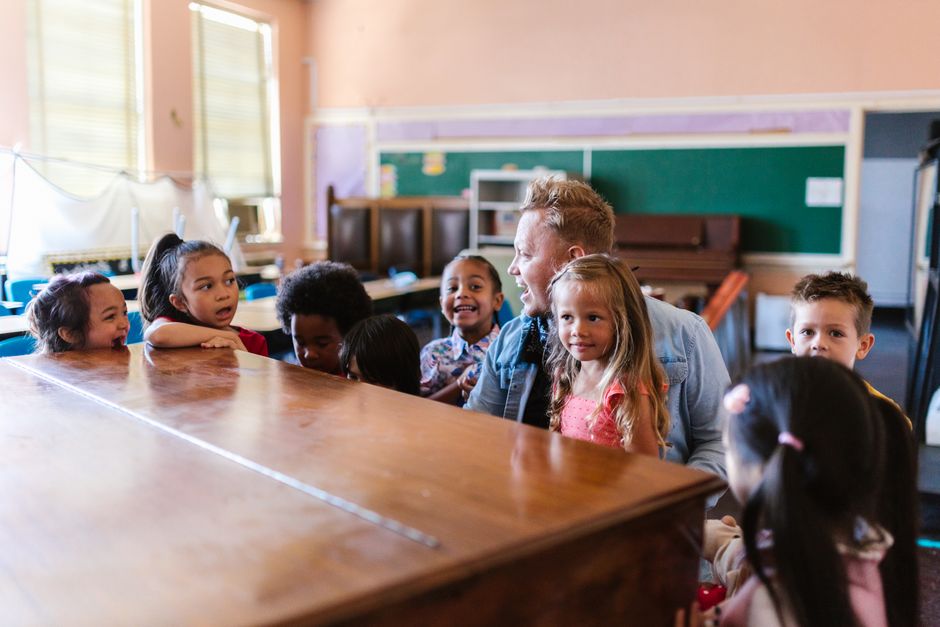 Grundschulklasse mit Kindern unterschiedlicher Herkunft beim Unterricht an der Tafel